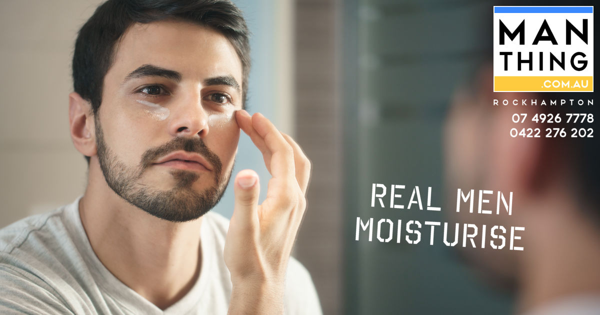 Handsome young man applying moisturiser in the mirror