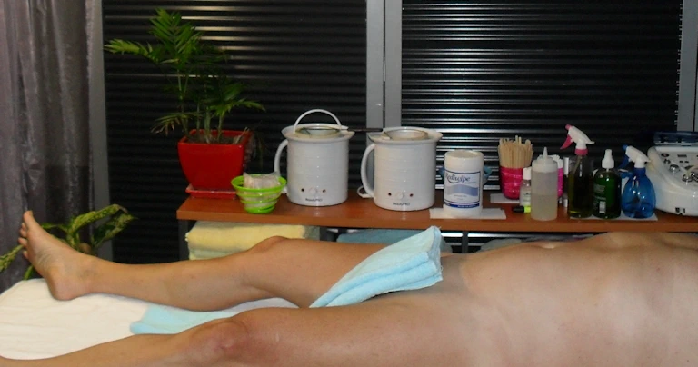 naked man covers his genitals with a towel for etiquette while waiting to be waxed